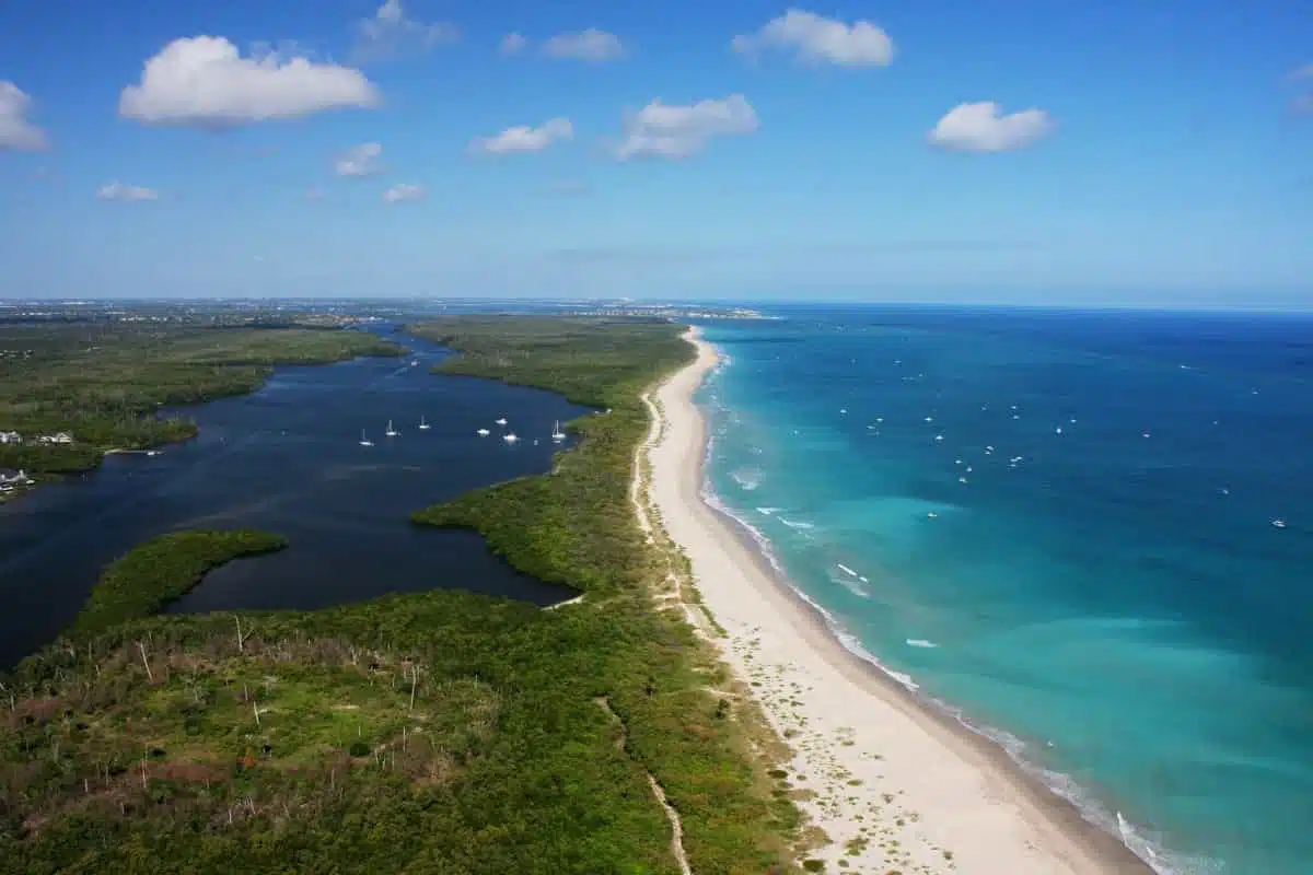 Ocean and Inlet at Hutchinson Island An aerial view of Hutchinson Island, where the Atlantic Ocean meets St Lucie Inlet, showcasing the beautiful coastline of Martin County, Florida. The image was taken by Martin County Office of Tourism & Marketing and highlights the hidden gem of Hutchinson Island mentioned in the article.